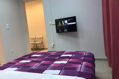 a bedroom with a purple bed with a tv on the wall at Athens Spirit 49 katechaki apartment in Athens