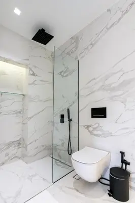 a bathroom with a toilet and a glass shower at NS PLACE Modern Apartment Acropolis view in Athens
