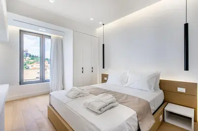 a white bedroom with a large bed with towels on it at NS PLACE Modern Apartment Acropolis view in Athens