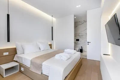 a bedroom with a bed and a flat screen tv at NS PLACE Modern Apartment Acropolis view in Athens