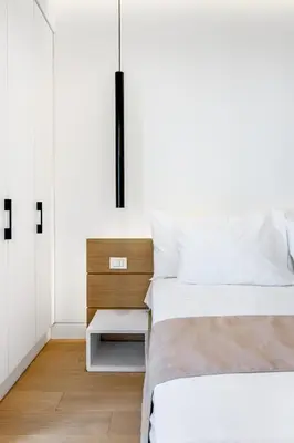 a white bedroom with two beds and a nightstand at NS PLACE Modern Apartment Acropolis view in Athens