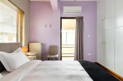 a bedroom with a large white bed and a window at Βright Walled Designed Apt in Glyfada Center 1Gbps in Athens