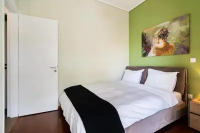a bedroom with a bed with a painting on the wall at Βright Walled Designed Apt in Glyfada Center 1Gbps in Athens