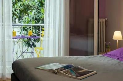 a bed with a magazine on it with a window at Stylish Modern Studio in the Heart of Athens in Athens