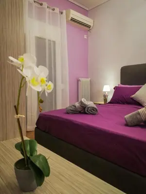 a bedroom with a purple bed and a white flower at Stylish Modern Studio in the Heart of Athens in Athens