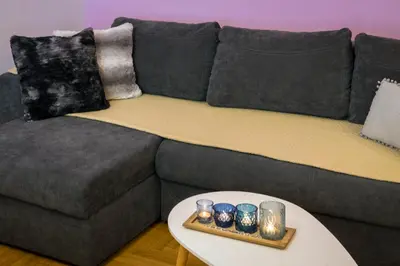 a grey couch with a table with candles on it at Stylish Modern Studio in the Heart of Athens in Athens
