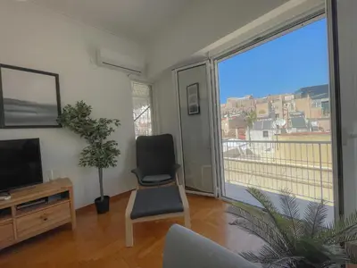 a living room with a chair and a large window at Acropolis Exceptional View II in Athens