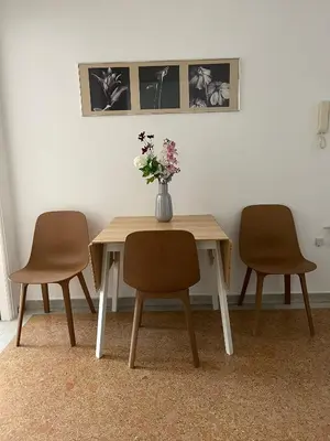 a table with two chairs and a vase with flowers on it at Acropolis Exceptional View II in Athens