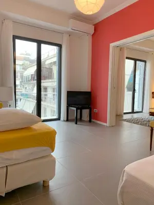 a bedroom with red walls and a bed and a balcony at New Modern Apartment - Athens Seaside - 3 Bedrooms in Athens