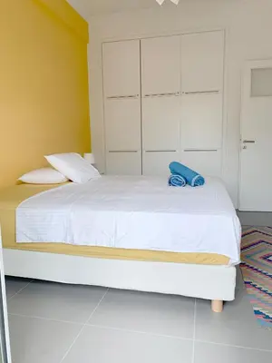 a bedroom with a white bed with a blue towel on it at New Modern Apartment - Athens Seaside - 3 Bedrooms in Athens