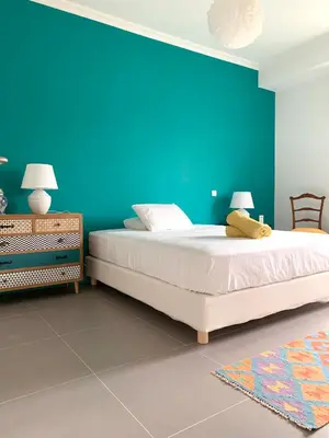 a bedroom with a large bed with a blue wall at New Modern Apartment - Athens Seaside - 3 Bedrooms in Athens