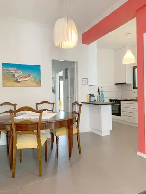 a kitchen and dining room with a wooden table and chairs at New Modern Apartment - Athens Seaside - 3 Bedrooms in Athens