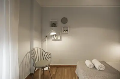 a bedroom with a chair and a bed and a lamp at Apollonos Amalia one bedroom in Athens