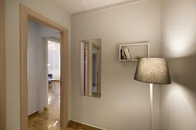 a hallway with a lamp and a mirror on a wall at Apollonos Amalia one bedroom in Athens