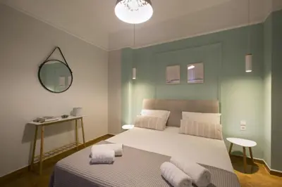 a bedroom with a large bed and a mirror at Apollonos Studio Amalia in Athens
