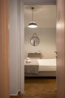 a bedroom with a bed and a mirror on the wall at Apollonos Studio Amalia in Athens