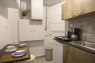 a kitchen with white cabinets and a wooden counter top at Apollonos Studio Amalia in Athens