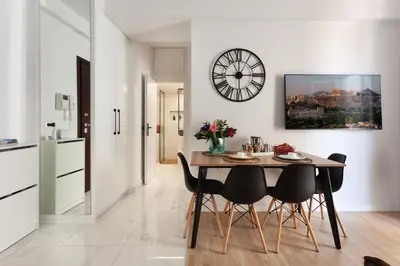 a kitchen and dining room with a table and chairs at Modern Comfort in the Heart of Athens in Athens