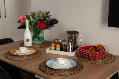 a table with two plates of food and a basket of bread at Modern Comfort in the Heart of Athens in Athens