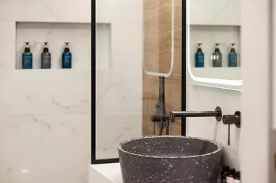 a bathroom with a sink and a shower with blue bottles at Modern Comfort in the Heart of Athens in Athens