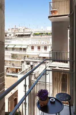 a balcony with a table and chairs and a city at Modern Comfort in the Heart of Athens in Athens