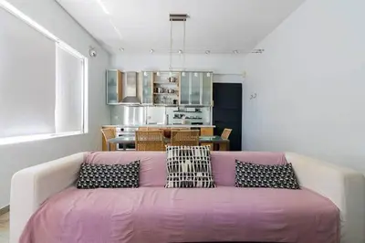 a living room with a pink couch with pillows at Unique Apartment near Acropolis in Athens