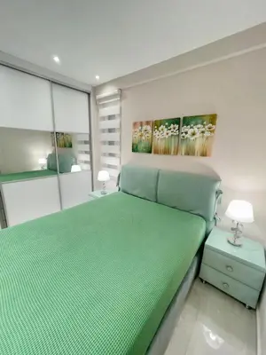 a bedroom with a green bed with a painting on the wall at Alimos Luxury Prestige in Athens