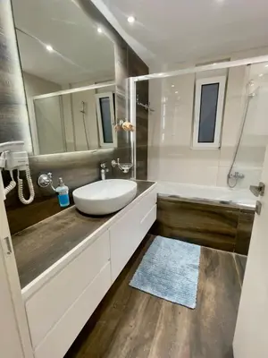 a bathroom with a sink and a tub and a mirror at Alimos Luxury Prestige in Athens