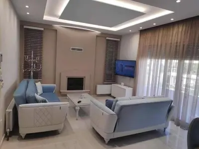 a living room with two couches and a tv at Alimos Luxury Prestige in Athens
