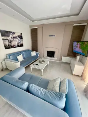 a living room with a blue couch and a tv at Alimos Luxury Prestige in Athens
