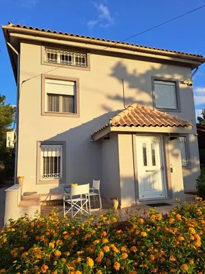 a white house with a table in front of it at Studio Katafigi in Anavissos