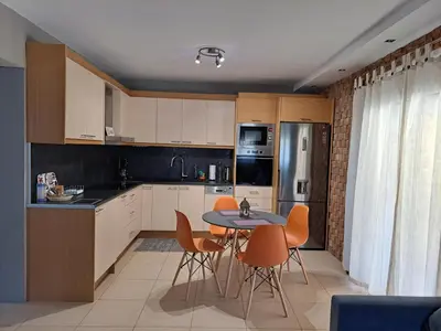 a kitchen with a table and chairs and a refrigerator at Studio Katafigi in Anavissos