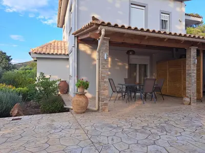 a patio of a house with a table and chairs at Studio Katafigi in Anavissos