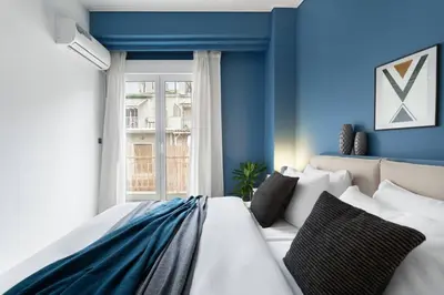 a bedroom with blue walls and a large bed at Bright, Modern Retreat Near Acropolis in Koukaki in Athens