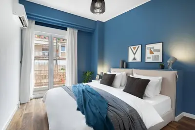 a bedroom with blue walls and a large bed at Bright, Modern Retreat Near Acropolis in Koukaki in Athens