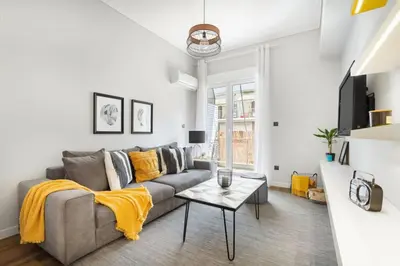 a living room with a gray couch and a table at Bright, Modern Retreat Near Acropolis in Koukaki in Athens