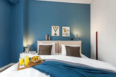 a blue bedroom with a bed with a bowl of fruit on it at Bright, Modern Retreat Near Acropolis in Koukaki in Athens