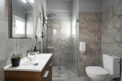 a bathroom with a toilet and a sink and a shower at Bright, Modern Retreat Near Acropolis in Koukaki in Athens