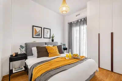 a bedroom with a large bed with a yellow blanket at Bright, Modern Retreat Near Acropolis in Koukaki in Athens
