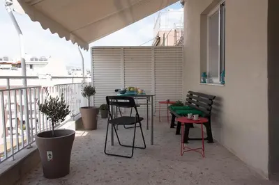 a balcony with a table and chairs on a balcony at EL GRECO Penthouse in Vibrant Petralona in Athens