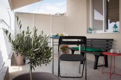 a room with a table and a bench and plants at EL GRECO Penthouse in Vibrant Petralona in Athens