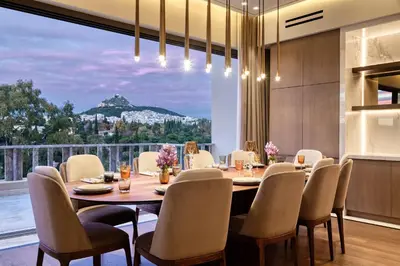 a dining room with a table and chairs and a large window at The One Acropolis in Athens