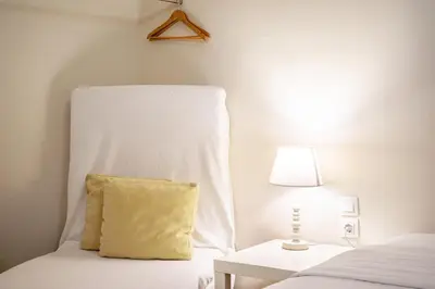 a white bed with a yellow pillow and a lamp at Zacharitsa APT at Acropolis up 4 guests by LODGESPOT in Athens