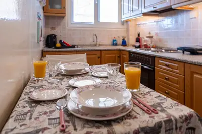 a kitchen with a table with plates and glasses on it at Sea view apartment 100m from the beach in Saronida