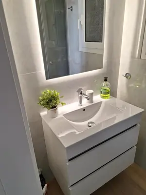 a bathroom with a white sink and a mirror at Sea view apartment 100m from the beach in Saronida