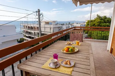 a table with food on top of a balcony at Sea view apartment 100m from the beach in Saronida