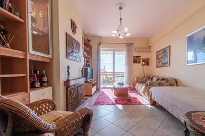 a living room with a couch and a table at Sea view apartment 100m from the beach in Saronida