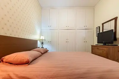 a bedroom with a large bed and a television at Sea view apartment 100m from the beach in Saronida