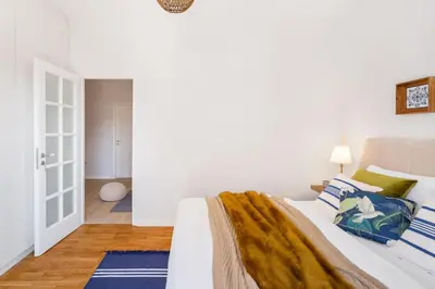 a white bedroom with a bed with blue pillows at Modern & Stylish Hideaway Downtown near Acropolis & Metro in Athens