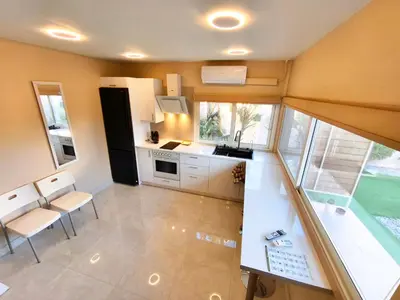 a kitchen with white cabinets and a large window at Modular Bungalows With Heated Pool Artemis Greece in Artemida